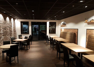 Die Holzwände hinter den Sitzwänden teilen das Café optisch in separate Bereiche auf.